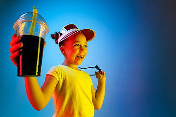 Image showing The happy teen girl standing and smiling against blue background.