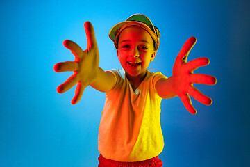 Image showing The happy teen girl standing and smiling against blue background.