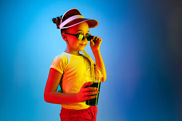 Image showing The happy teen girl standing and smiling against blue background.