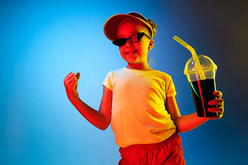 Image showing The happy teen girl standing and smiling against blue background.