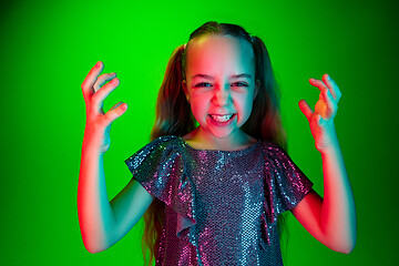 Image showing Portrait of angry teen girl over green studio background