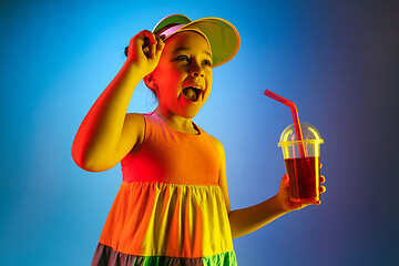 Image showing The happy teen girl standing and smiling against blue background.