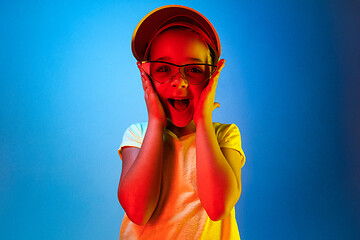 Image showing The happy teen girl standing and smiling against blue background.