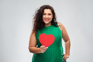 Image showing happy woman in green dress holding red heart