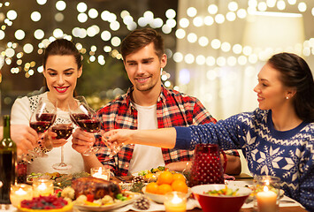Image showing happy friends drinking red wine at christmas party
