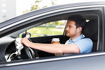 Image showing tired man driving car with takeaway coffee