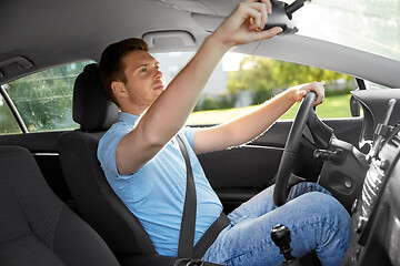 Image showing man or car driver adjusting mirror