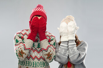 Image showing couple in ugly sweaters and mittens on christmas