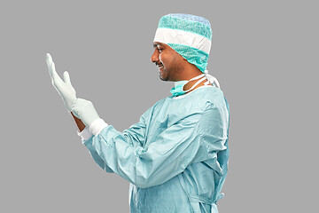 Image showing indian male doctor or surgeon putting glove on