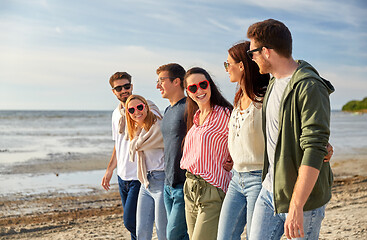 Image showing happy friends walking along summer beach