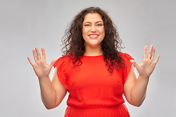 Image showing happy woman in red dress showing hand palms