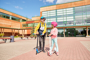 Image showing happy school children with backpacks and scooters