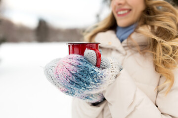 Image showing happy young woman with tea cup in winter park