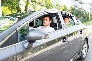 Image showing male driver driving car with passenger