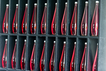 Image showing bottles of red juice in modern restaurant