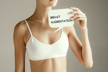 Image showing Woman health. Female model holding card near breast