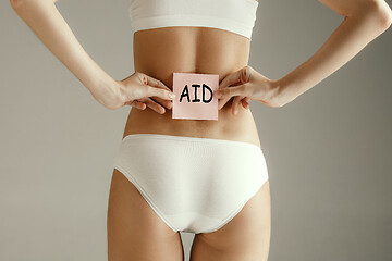 Image showing Beautiful young body. Naked back of a woman, isolated on gray background.