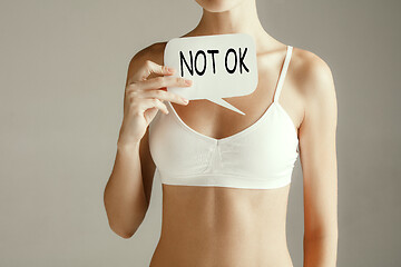 Image showing Woman health. Female model holding card near breast