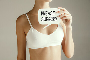 Image showing Woman health. Female model holding card near breast