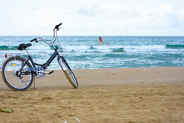 Image showing The bike stands on the sandy sea beach