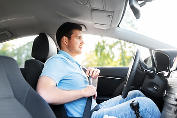 Image showing man or car driver fastening seat belt