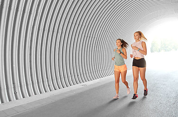 Image showing women or female friends with earphones running