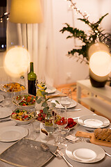 Image showing table served with plates, wine glasses and food