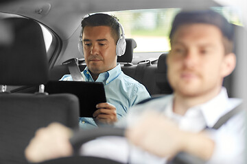 Image showing man with tablet pc and headphones riding in car