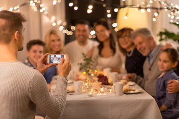 Image showing man taking picture of family at dinner party
