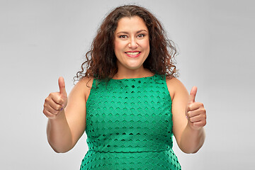 Image showing happy woman in green dress showing thumbs up