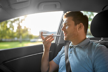 Image showing passenger recording voice on smartphone in car