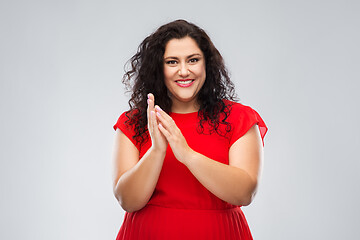 Image showing happy woman in red dress applauding
