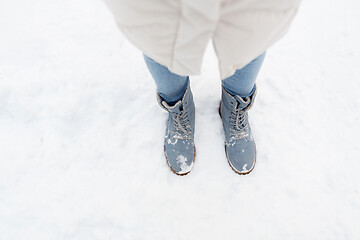 Image showing female feet in winter shoes on snow from top