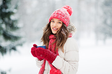 Image showing happy young woman with tea cup in winter park