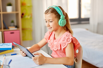 Image showing girl in headphones with tablet computer at home