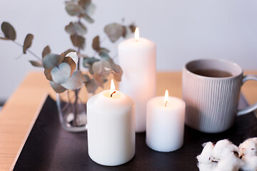 Image showing candles, tea and branches of eucalyptus on table