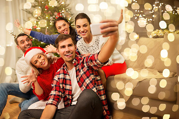 Image showing friends celebrating christmas and taking selfie