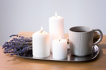 Image showing candles, tea in mug and lavender flowers on table