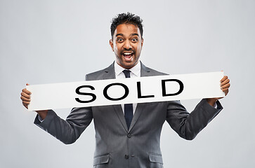 Image showing happy indian male realtor with sold banner