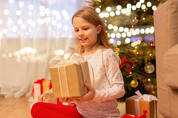 Image showing smiling girl with christmas gift at home