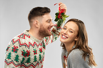 Image showing happy couple kissing under the mistletoe