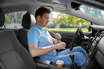 Image showing man or car driver fastening seat belt