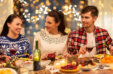 Image showing happy friends having christmas dinner at home