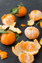 Image showing close up of peeled mandarins on slate table top