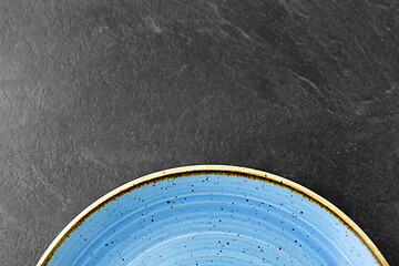 Image showing close up of blue ceramic plate on slate background