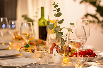 Image showing table served with plates, wine glasses and food