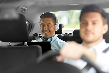 Image showing man with tablet pc and headphones riding in car