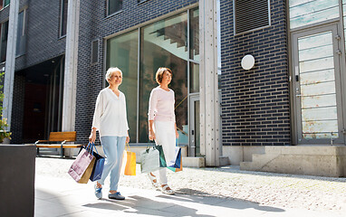 Image showing senior women with shopping bags walking in city