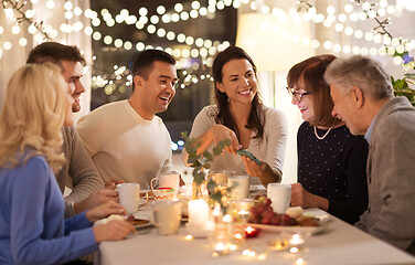 Image showing happy family with smartphone at tea party at home