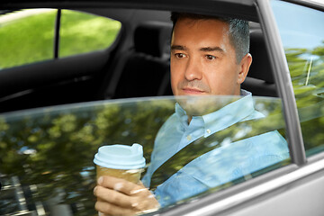 Image showing man drinking takeaway coffee on car back seat